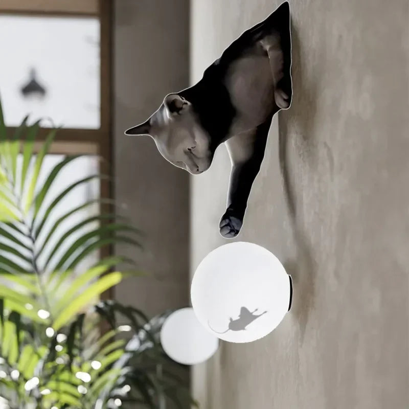Cat-shaped wall light fixture on a wall with a plant in the foreground