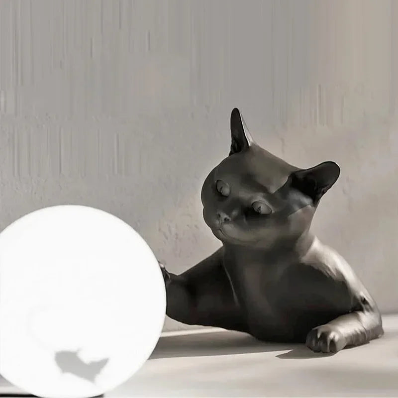 Black cat-shaped lamp on a white surface with a neutral background