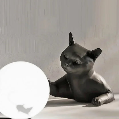 Black cat-shaped lamp on a white surface with a neutral background