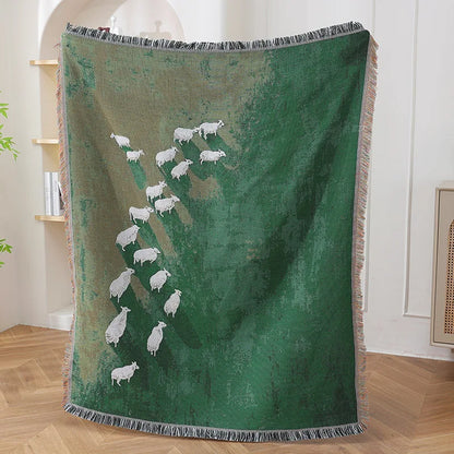 Green blanket with white sheep design draped over a chair in a room.