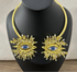 Gold necklace with eye design on a black mannequin against a neutral background