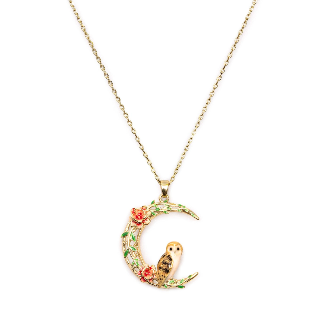 Gold crescent moon pendant necklace featuring a small owl and red flowers, displayed on a clean white background.